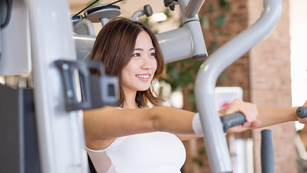 トレーニングマシンを使っている女性の写真