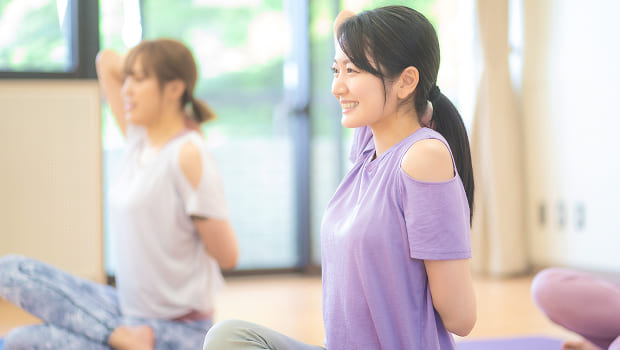 ジムのスタジオでヨガレッスンを受ける女性の写真