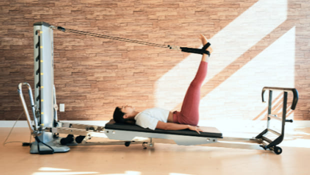 ピラティスマシンでトレーニングをする女性の写真